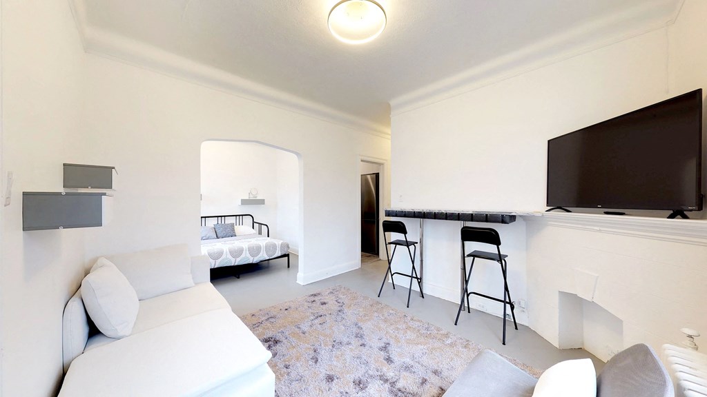 a living room with a couch and a bar and a television