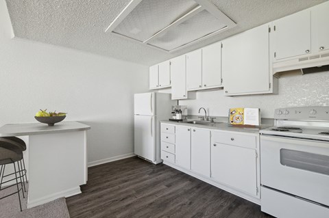 A kitchen with white cabinets and appliances.