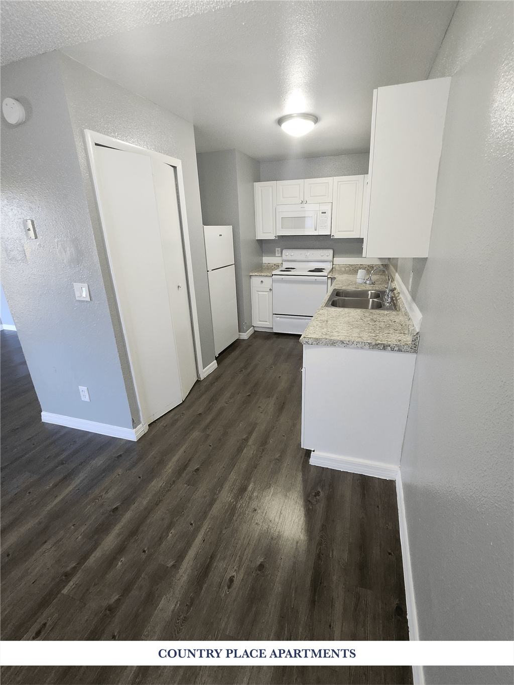 A kitchen with white appliances and cabinets.