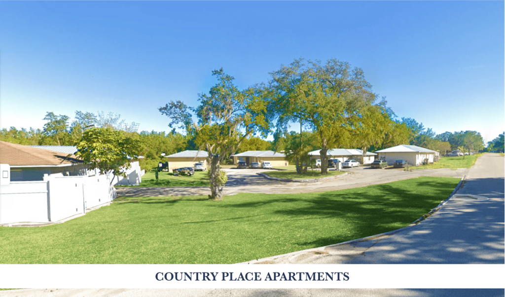 Apartment complex with green grass and trees.
