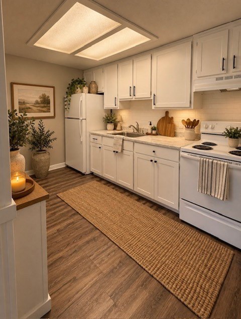 A kitchen with white cabinets and a wooden floor.