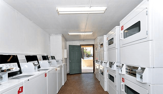 A row of white appliances are lined up in a room.