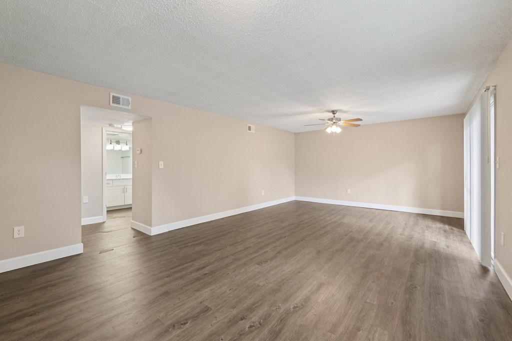 A room with wooden flooring and a ceiling fan.