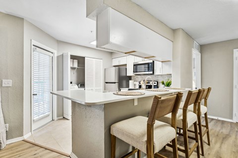 a kitchen with a bar with four chairs
