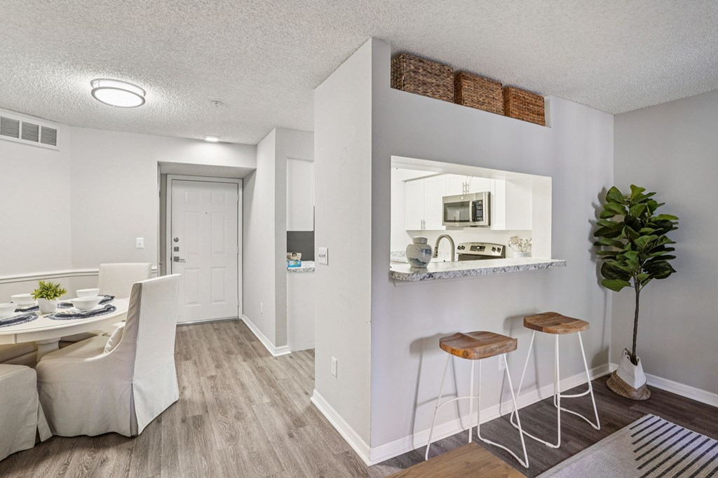 A kitchen with a dining table and chairs.