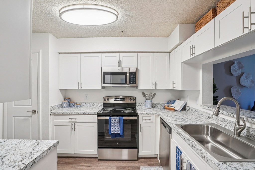 A kitchen with a stove, microwave, and oven.
