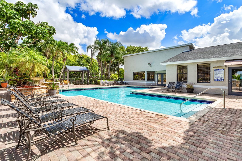 A pool with a black metal bench next to it.