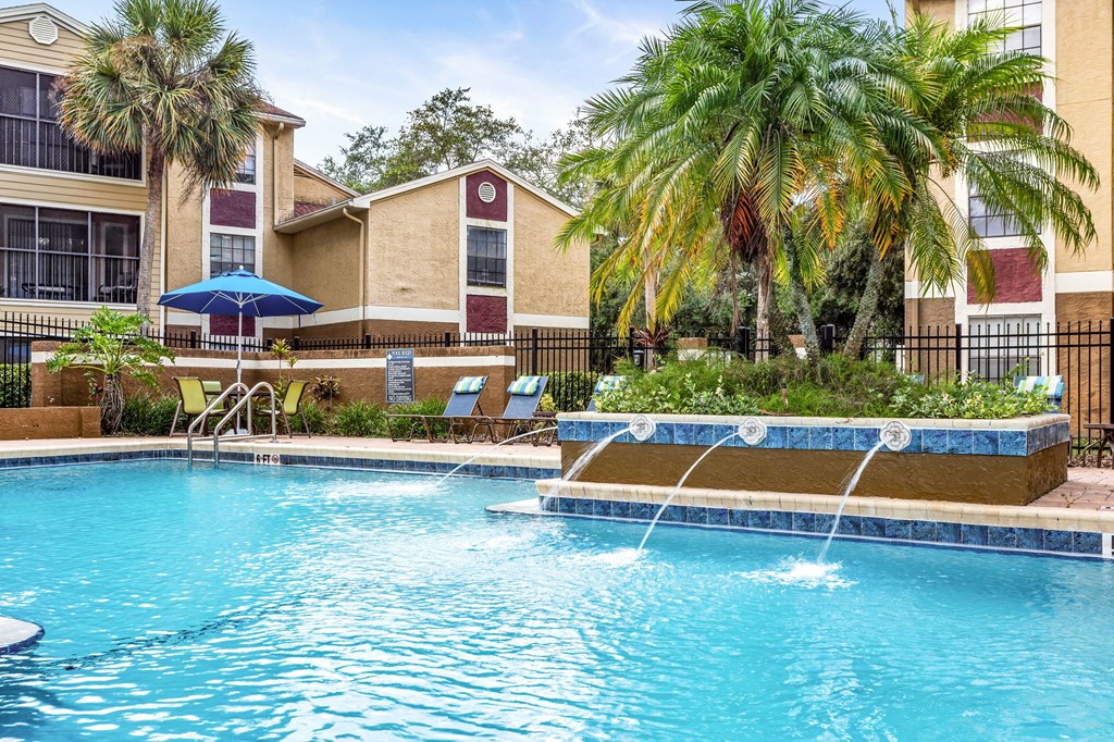 A swimming pool with a slide and a fence.