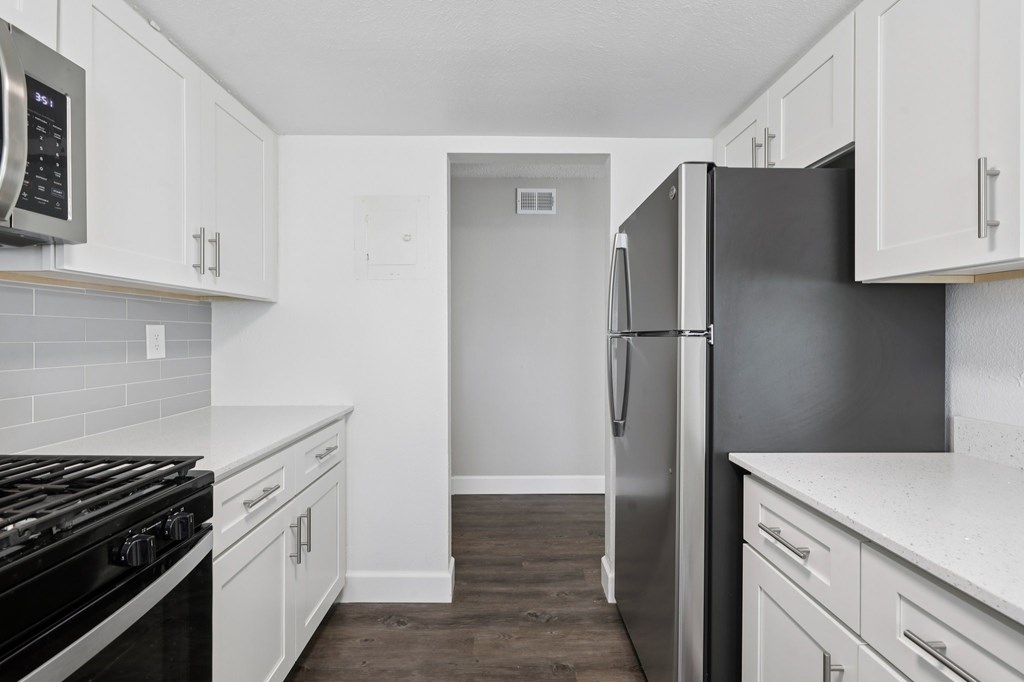 A kitchen with white cabinets and a black stove top oven.