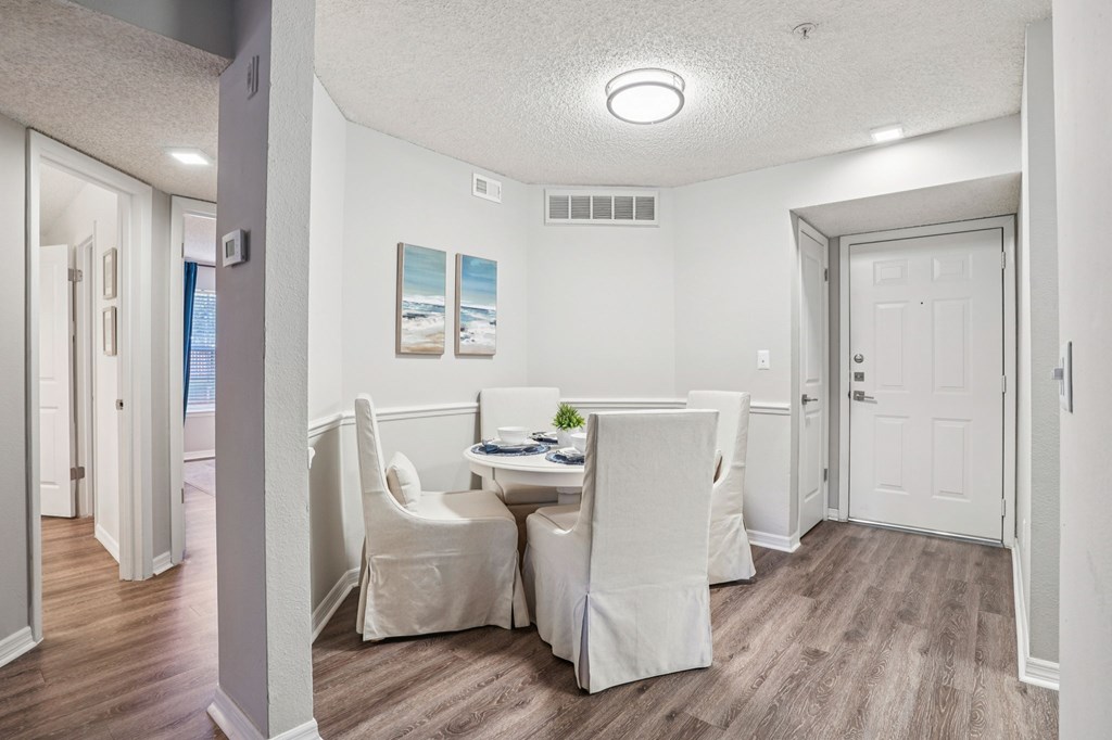 A dining room with a table and chairs.