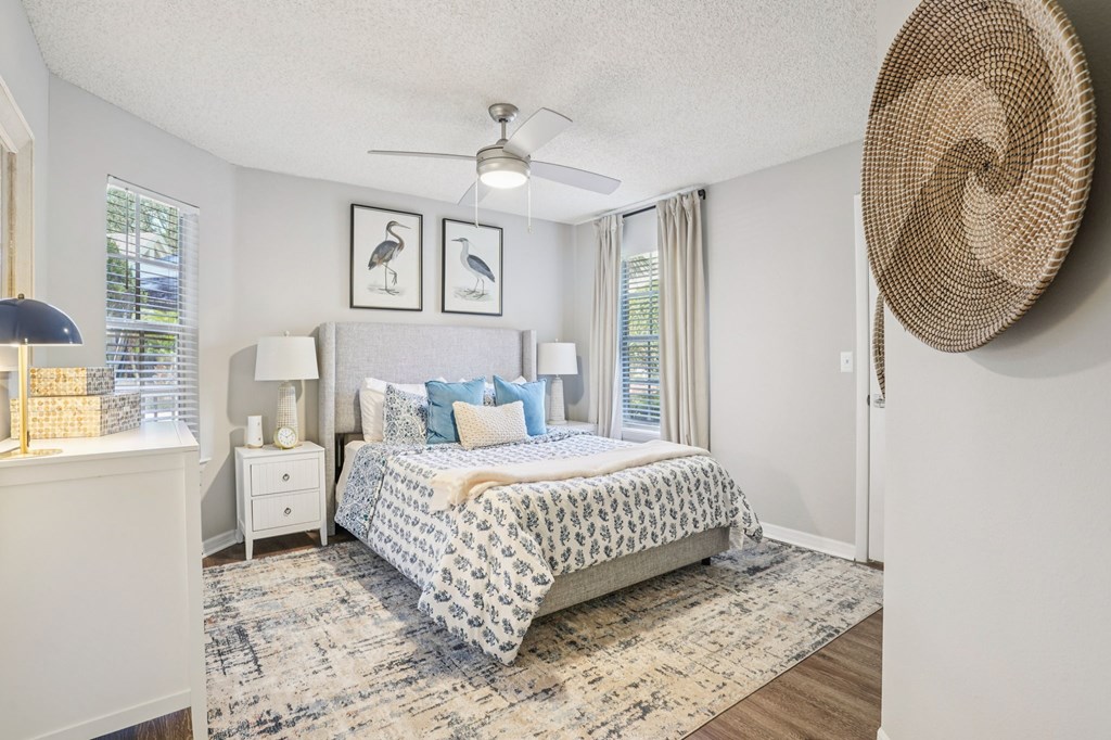 A bedroom with a large bed and a ceiling fan.