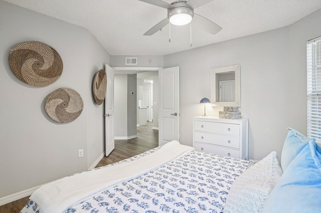 A bedroom with a bed, dresser, and mirror.