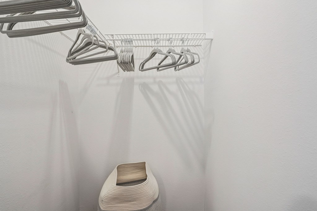 A white chair is under a clothes drying rack.