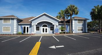 the front of a building with a parking lot and palm trees at Reserve at Temple Terrace, Temple Terrace, FL