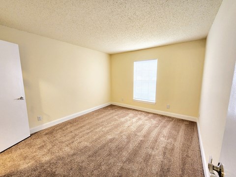 an empty room with carpet and a window at Sunscape Apartment Homes, Florida