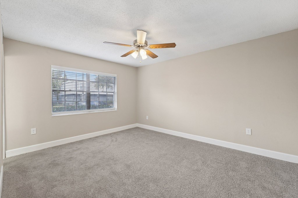 A room with a ceiling fan and a window.