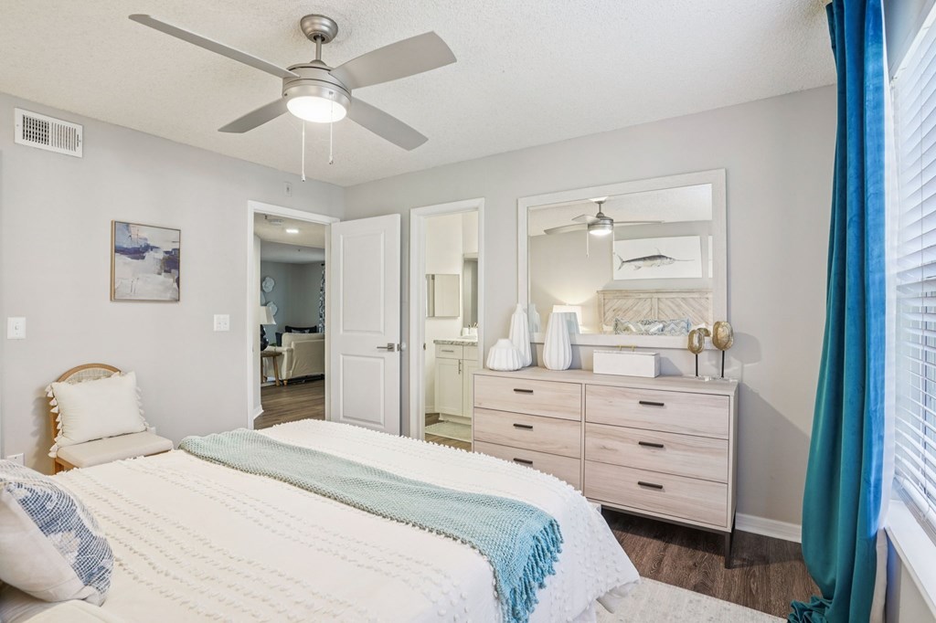 A bedroom with a bed, dresser, and mirror.