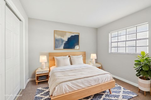 A bedroom with a large bed and a painting on the wall.