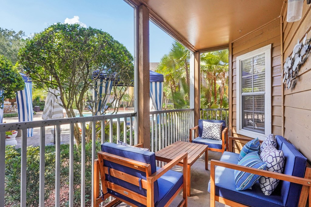 A wooden chair and table are on a porch.