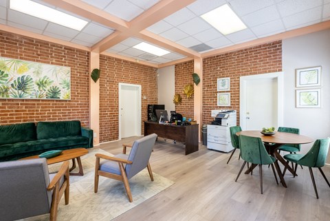 A living room with a green couch and a dining table with chairs.