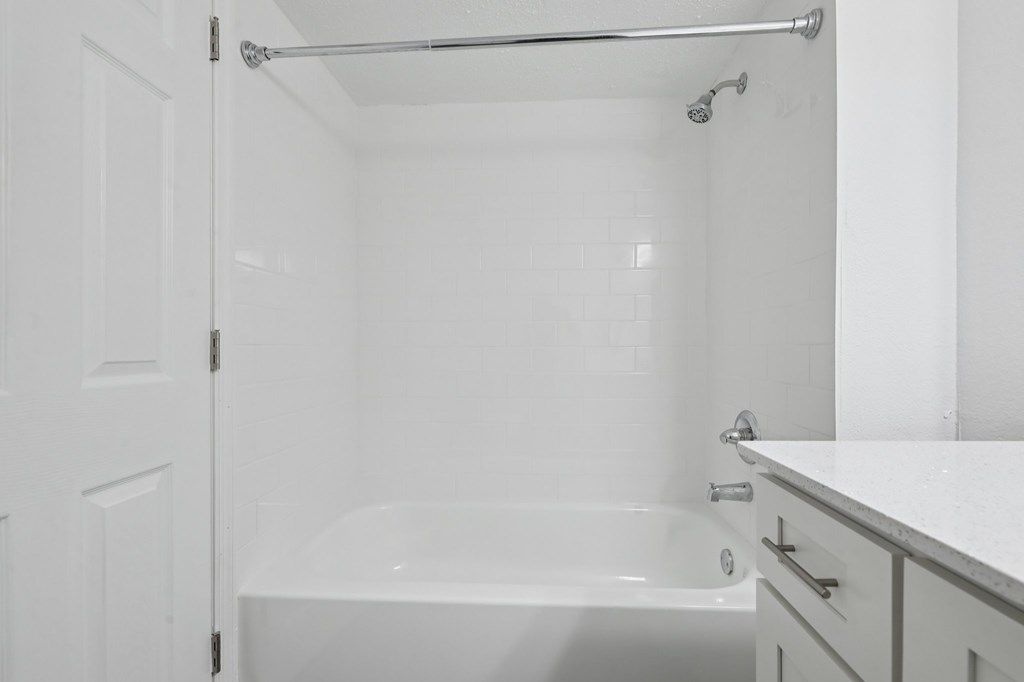 A white bathroom with a tub and a shower.