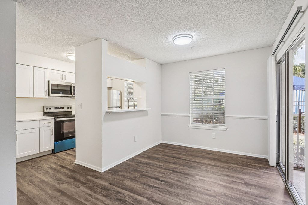 A kitchen with white cabinets and a microwave above the oven.