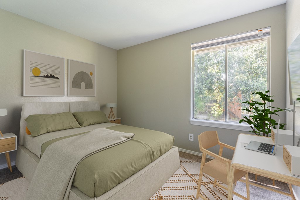 A bedroom with a bed, desk, and chair.