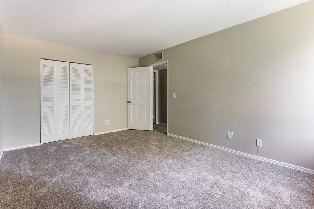 A room with a carpeted floor and a white door.