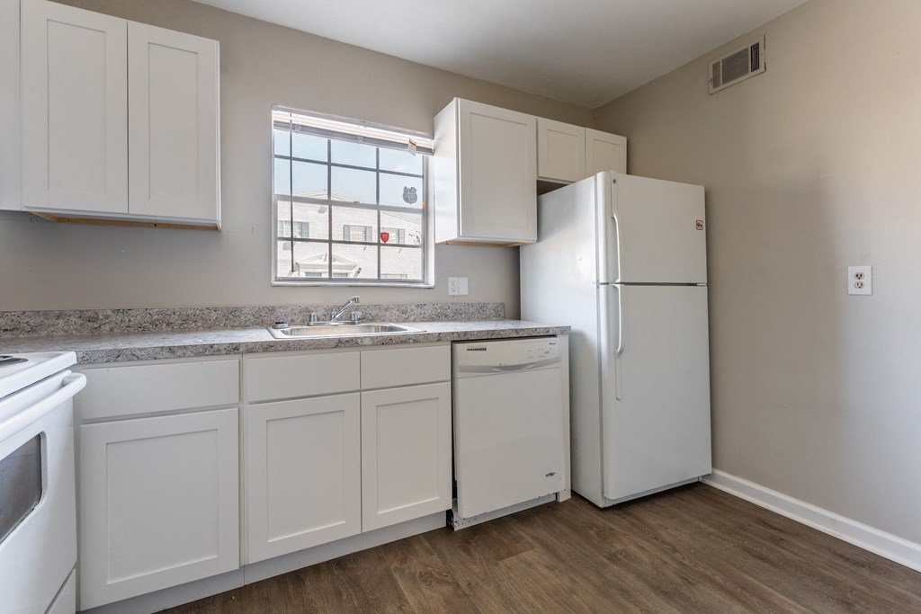 A kitchen with white appliances and cabinets.