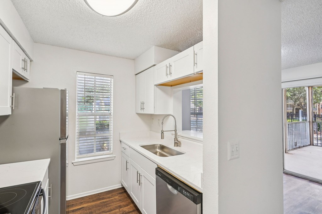 A kitchen with white cabinets and a black stove top oven.