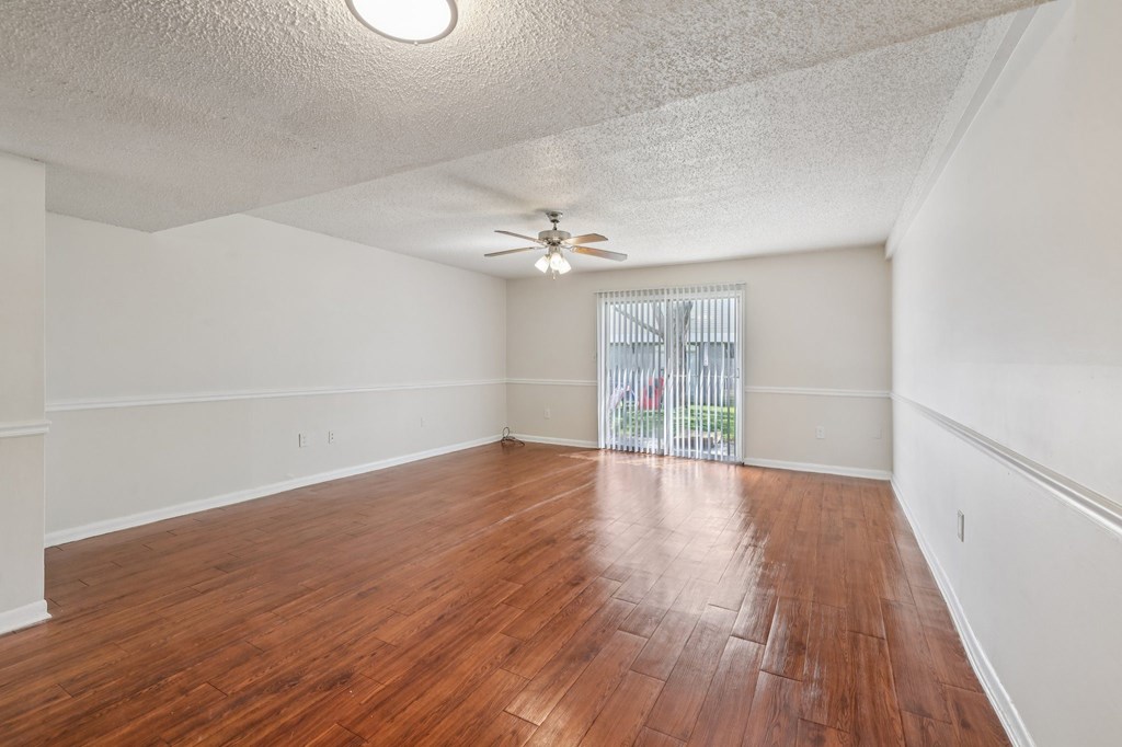A room with wooden flooring and a ceiling fan.