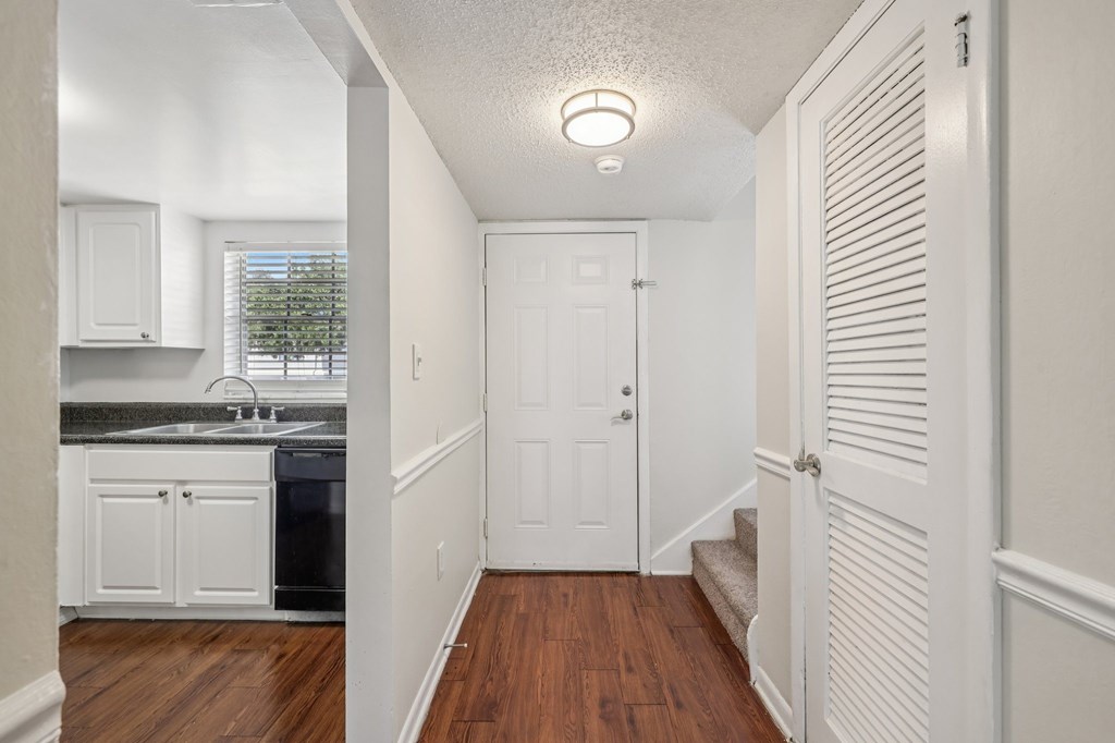 A white door is at the end of a hallway.