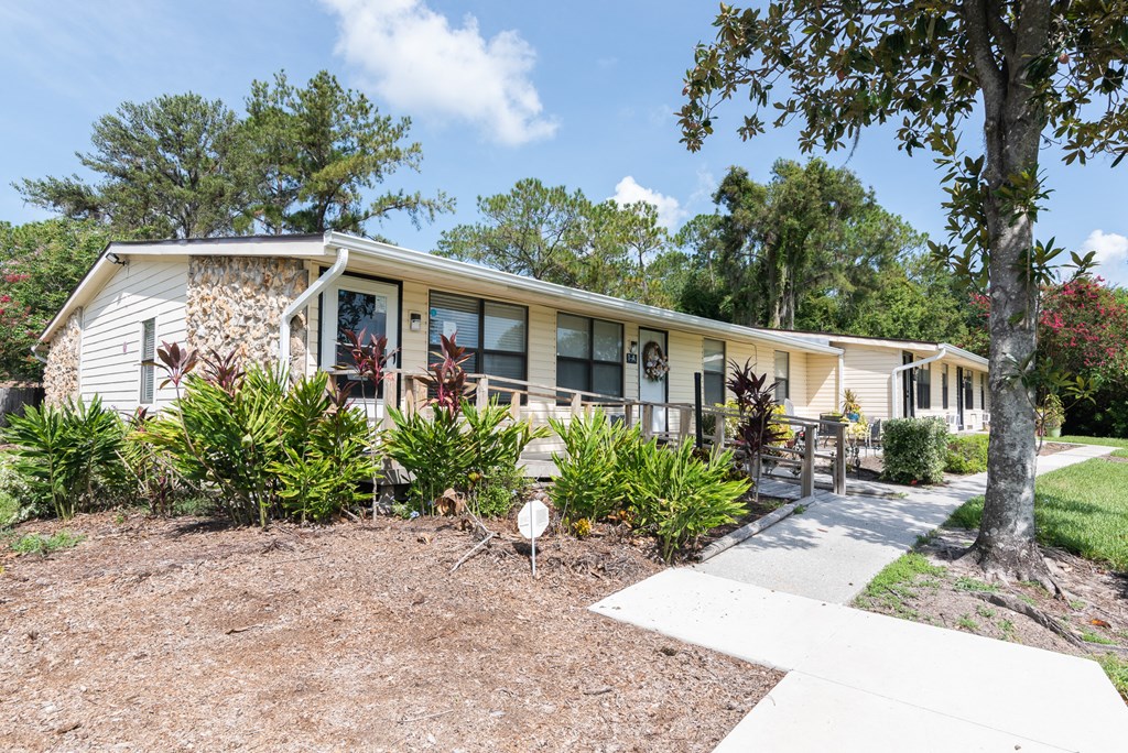 a white house with a porch and a sidewalk in front of it