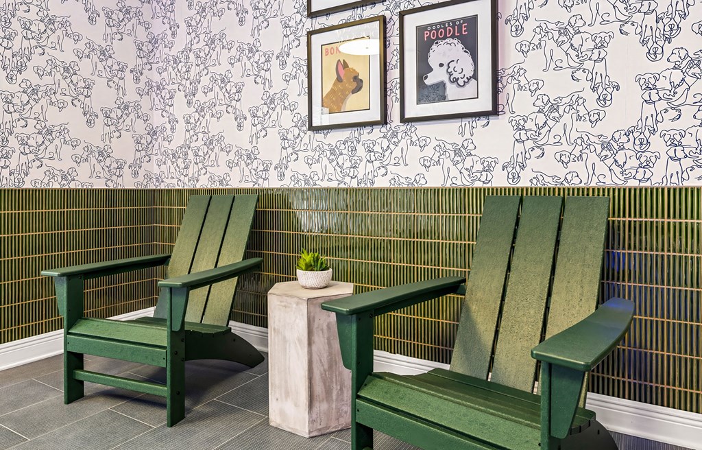 Two green chairs and a small table with a plant on it.