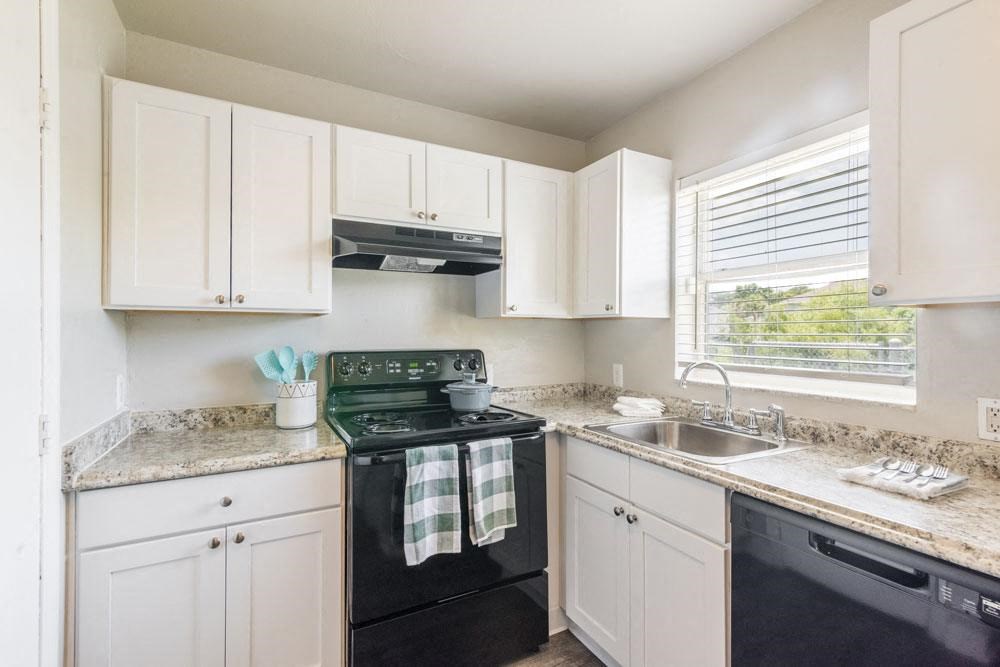 Apartment kitchen with white cabinets and black appliances_Rolling Hills Apartments