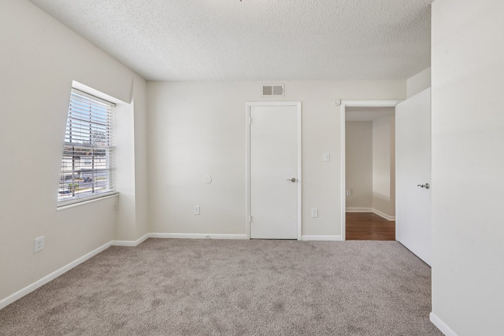 A room with a carpeted floor and white walls.