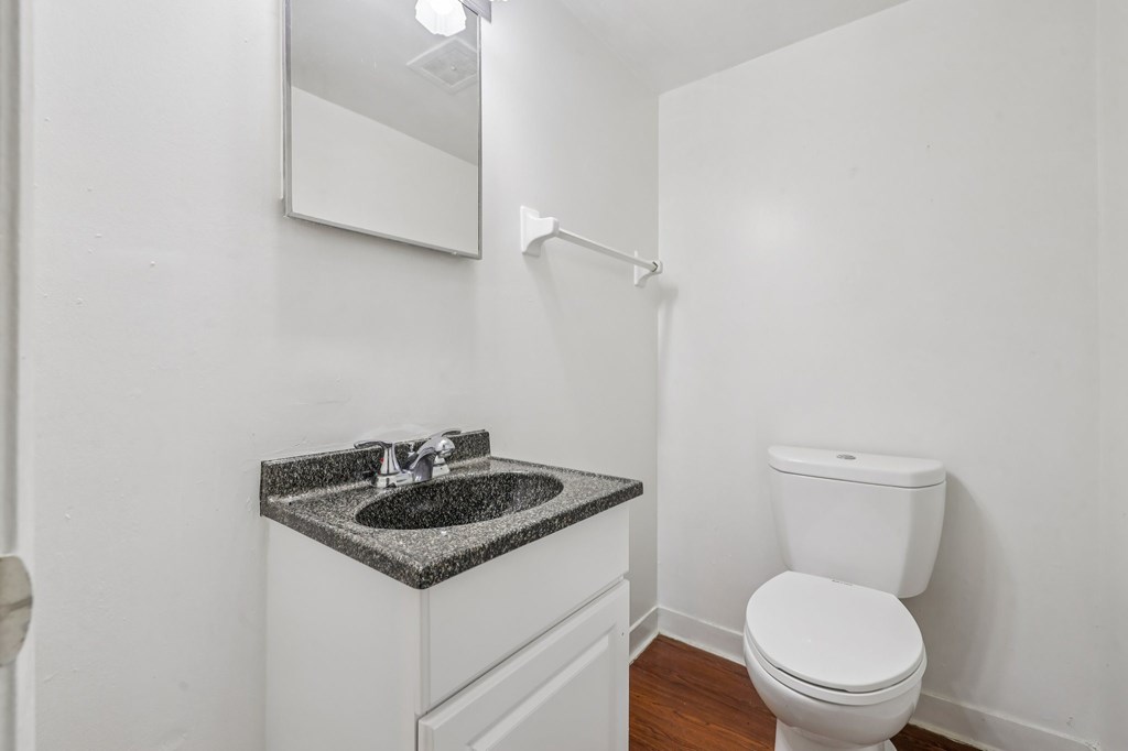 A white toilet sits next to a sink in a small bathroom.