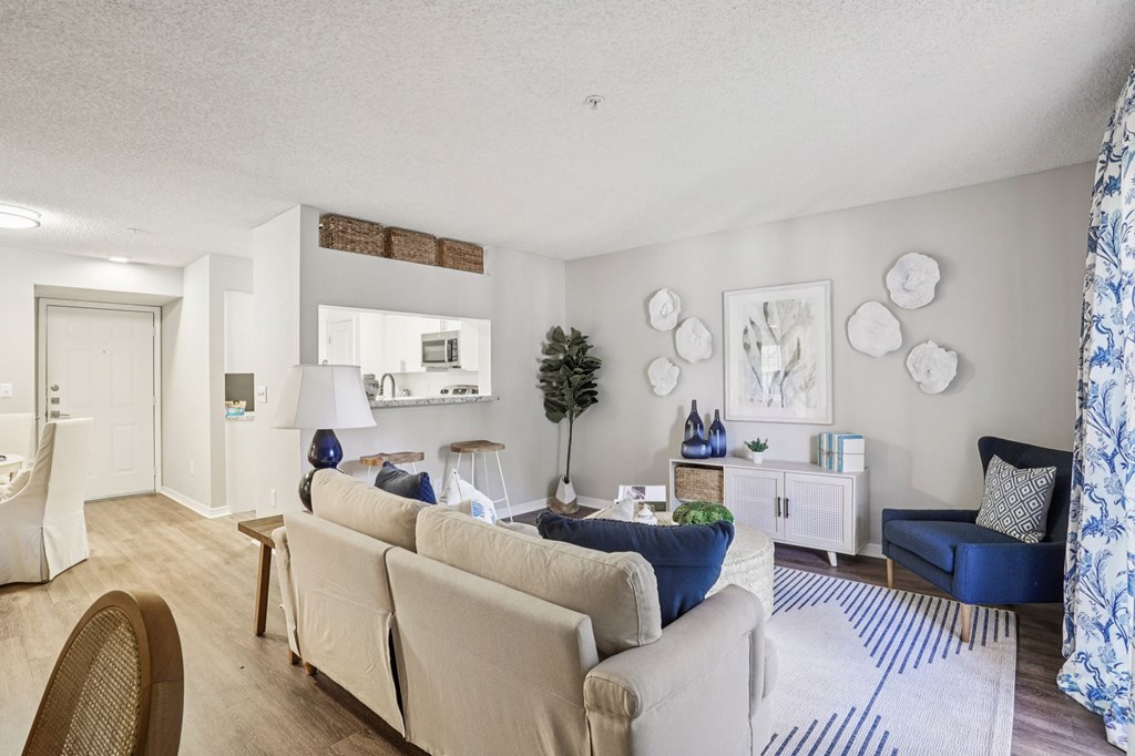 A living room with a white couch and a blue chair.