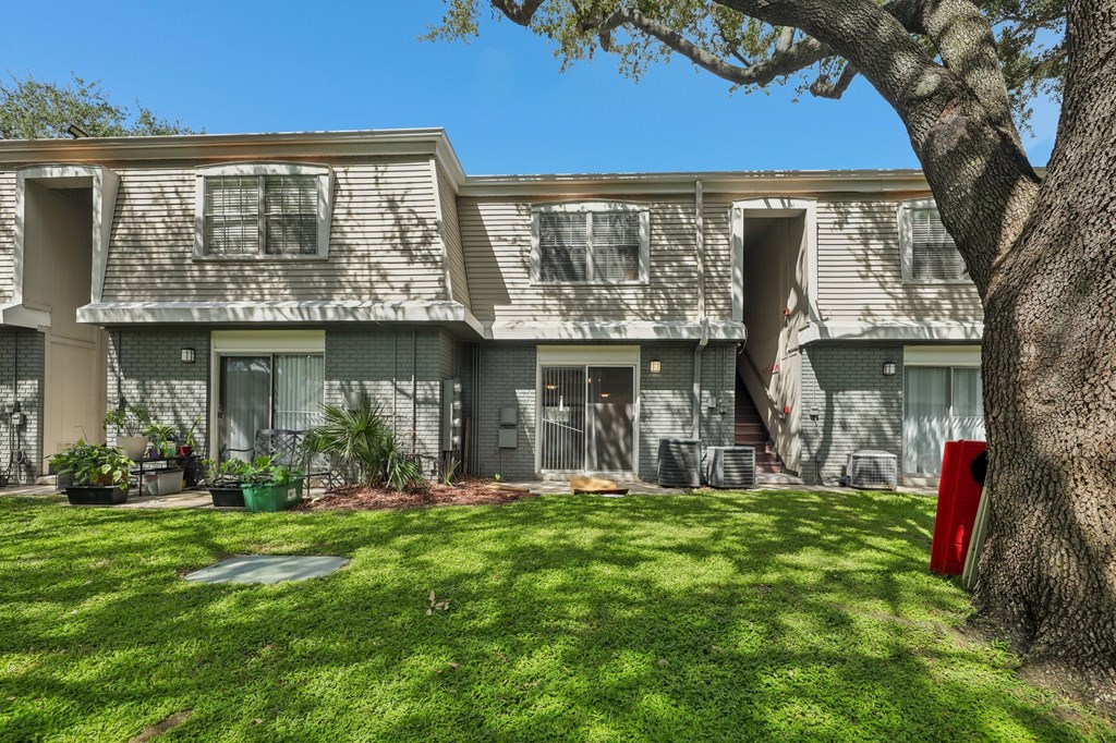 A tree is next to a building with a red mailbox.
