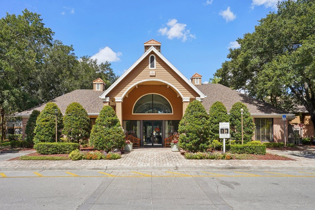 A building with a brown roof and a white sign in front of it.