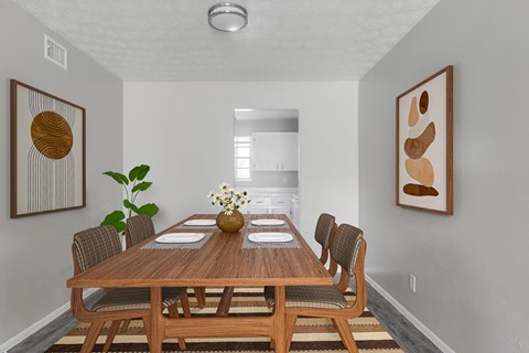 A dining room with a wooden table and chairs.