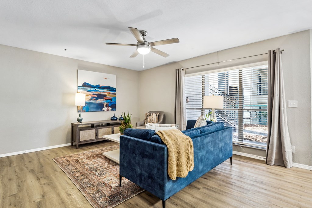 a living room with a blue couch and a ceiling fan at Reserve at Temple Terrace, Temple Terrace