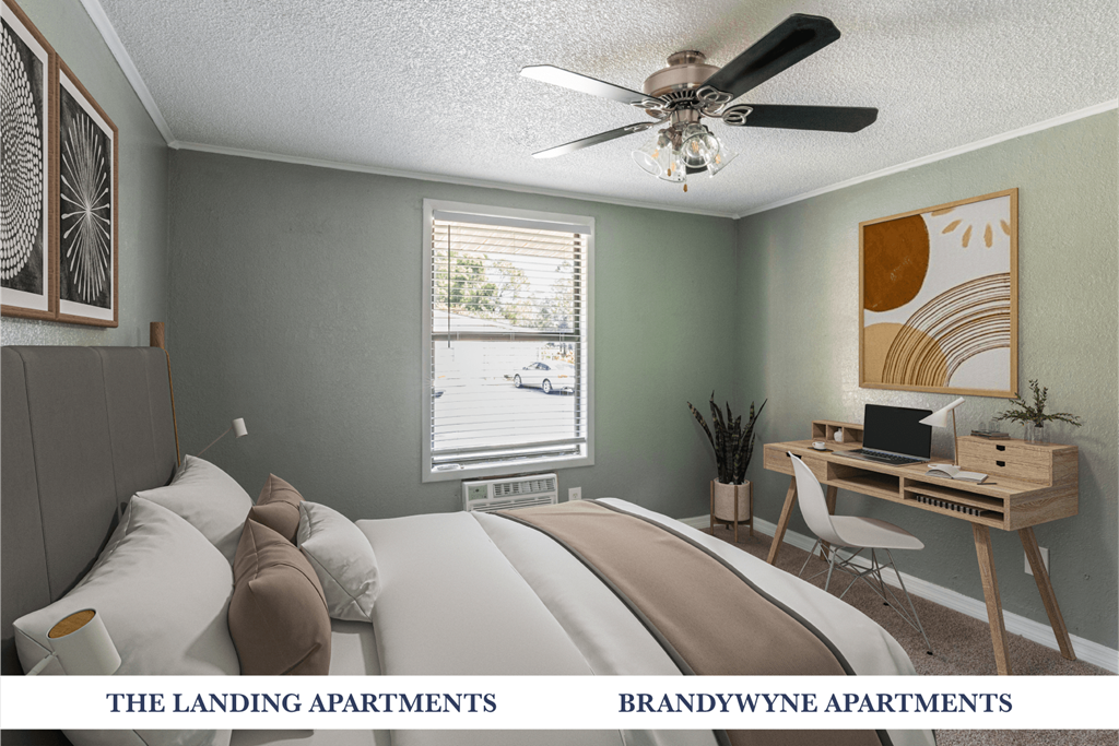 A bedroom with a bed, desk, and window.