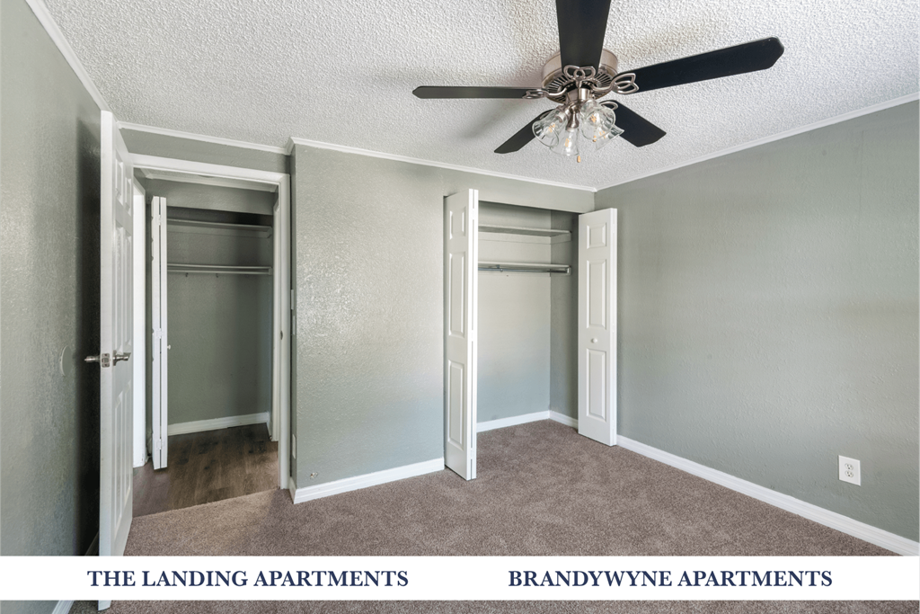 A room with a ceiling fan and two doors.