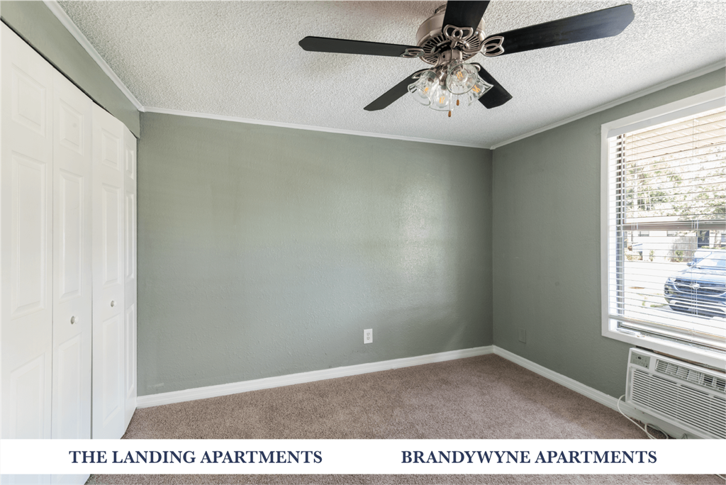 A room with a ceiling fan and a window with blinds.
