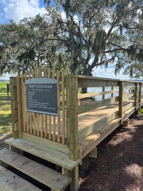 A wooden dock with a sign that says "Boat Dock Rules".