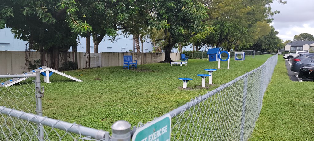 a park with benches and tables in the grass