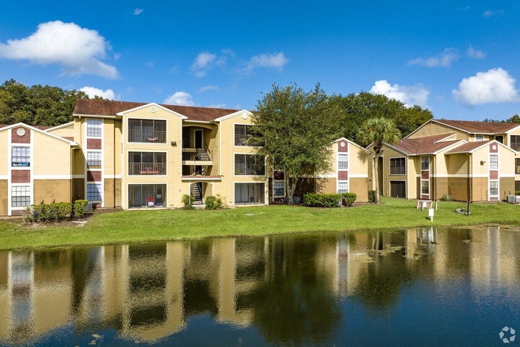 A row of apartment buildings are reflected in the water.