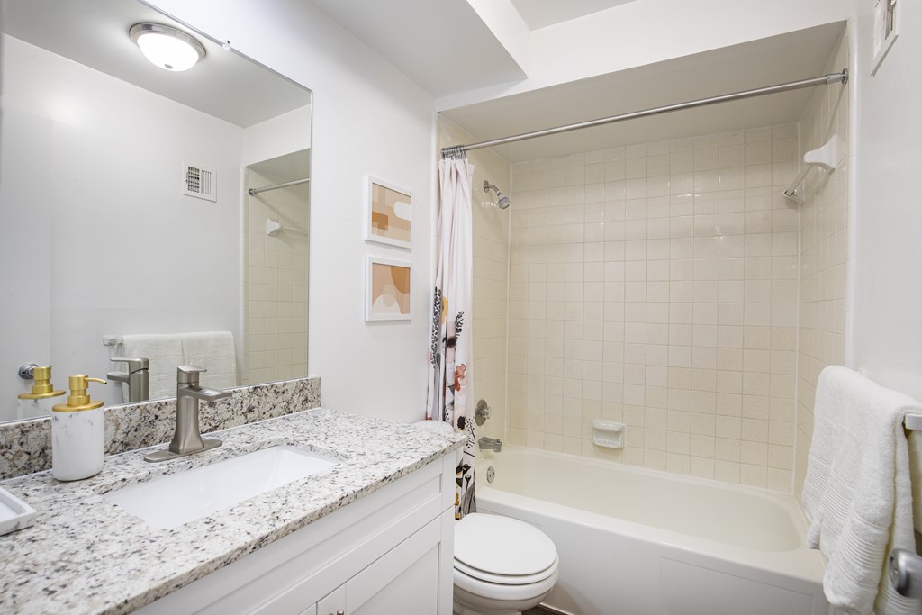 A white bathroom with a sink, toilet, and bathtub.