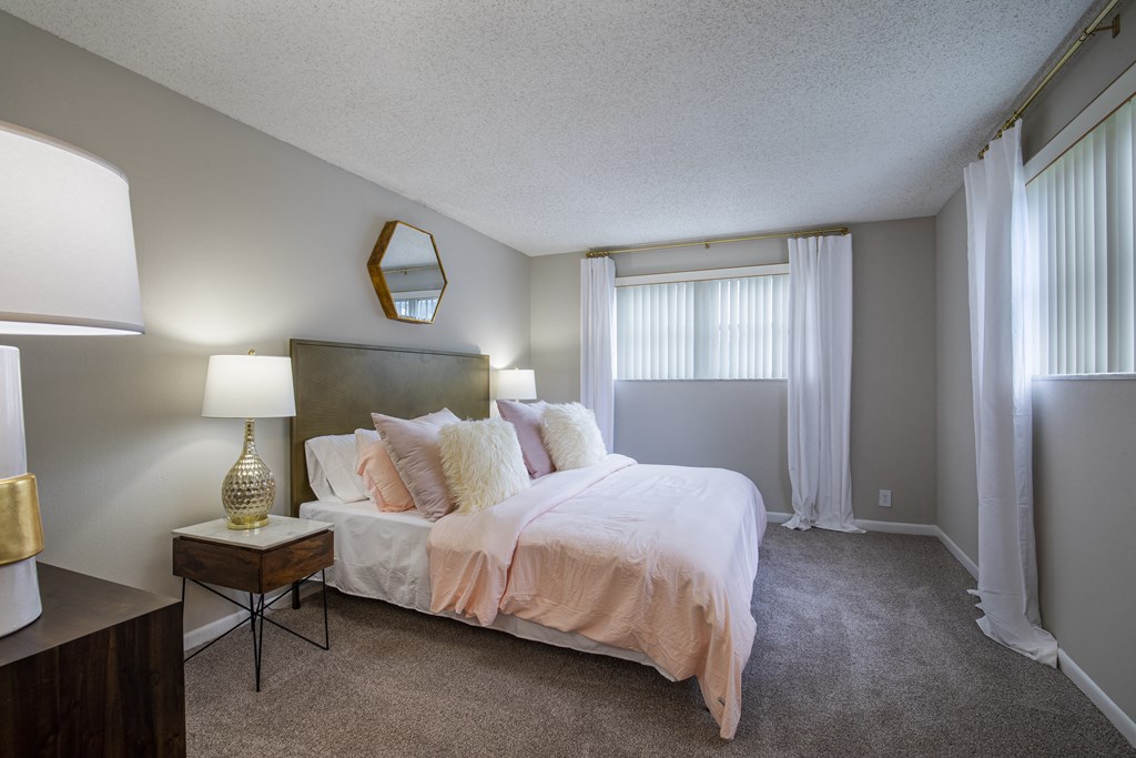 A bedroom with a bed, nightstand, and lamp.